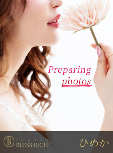 Close-up of a woman with wavy hair about to sniff a pale pink flower, with 'Preparing photos' in pink script and a dark banner of logos at the bottom.