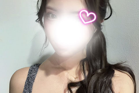 Portrait of a woman with dark hair in a ponytail, face washed out by bright light, neon pink heart near her eye, with a BLISS RICH watermark at the bottom.