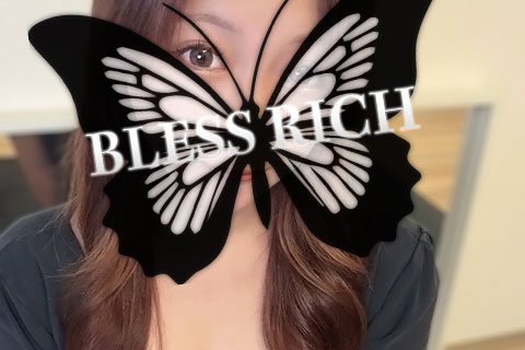 Portrait of a woman with long brown hair, a large black butterfly graphic covering her face with the text 'BLESS RICH' across it and a gold 'BLESS RICH' logo near the bottom.